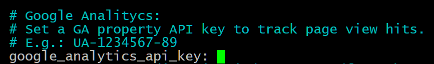 Captura de tela de um trecho de código de configuração. No topo, há três linhas de comentários em azul claro com instruções para configuração do Google Analytics, incluindo a definição de uma chave de API da propriedade GA e um exemplo no formato "UA-1234567-89". Abaixo, há uma linha de código em branco com o parâmetro `google_analytics_api_key:` seguido de um cursor de digitação em verde, indicando que o campo está pronto para receber um valor. O fundo é preto, típico de um terminal ou editor de código com tema escuro.